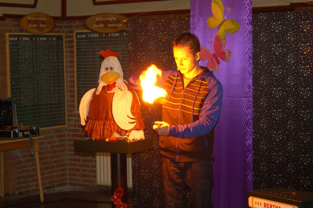 Tijdens een spectaculaire goochelshow laat de leukste Goochelaar van Nederland het publiek versteld staan met een spannende vuurtruc. Naast hem verschijnt zijn bekende assistente Bertha de Goochelkip-de vrolijke kippenpop in een opvallende rode jurk. Op het kleurrijk versierde podium, vol vlinders en met een levendige paarse achtergrond, genieten jong en oud samen van magisch entertainment vol humor, interactie en verrassingen. 
